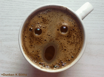 Gif mostra uma xícara cheia de café. A foto mostra a xícara de cima e o café forma uma espuma que parece uma expressão humana de espanto